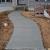 This is a Sidewalk from the driveway to the front door, along with steps.